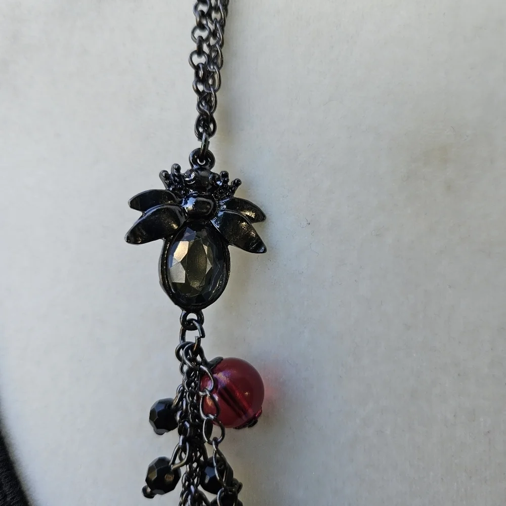 dark layered necklace with red beads flower spider fly charms